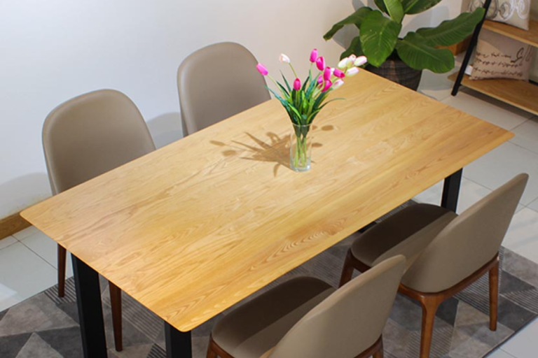 Bộ bàn ăn gỗ tần bì sáng màu với lọ hoa đặt ở giữa và bốn ghế xung quanh