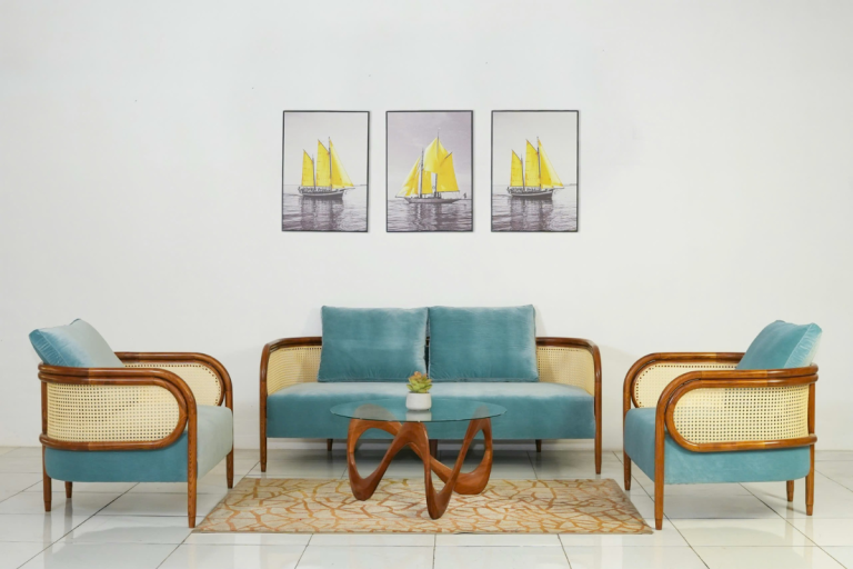 Bộ sofa Themis gồm sofa băng ba và hai sofa đơn bọc vải xanh nhạt, khung gỗ bo cong kết hợp mây đan, bố trí phòng khách hiện đại.