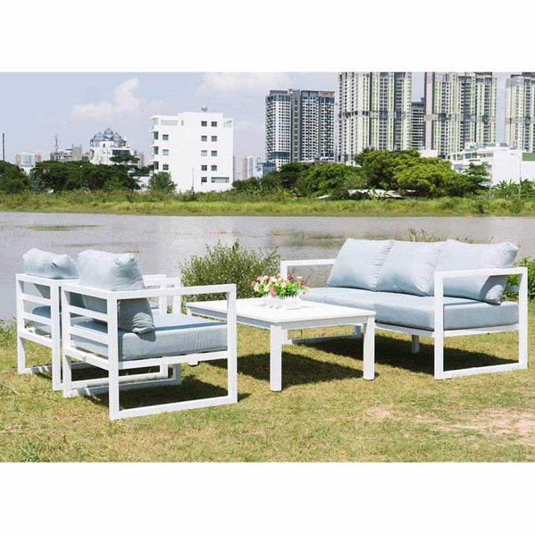 Bộ bàn ghế ngoài trời Paxi khung kim loại sơn trắng, đệm xám nhạt, thiết kế hiện đại đặt trên bãi cỏ ven hồ.